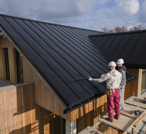 Vertical slider full shot roofers working together with helmets